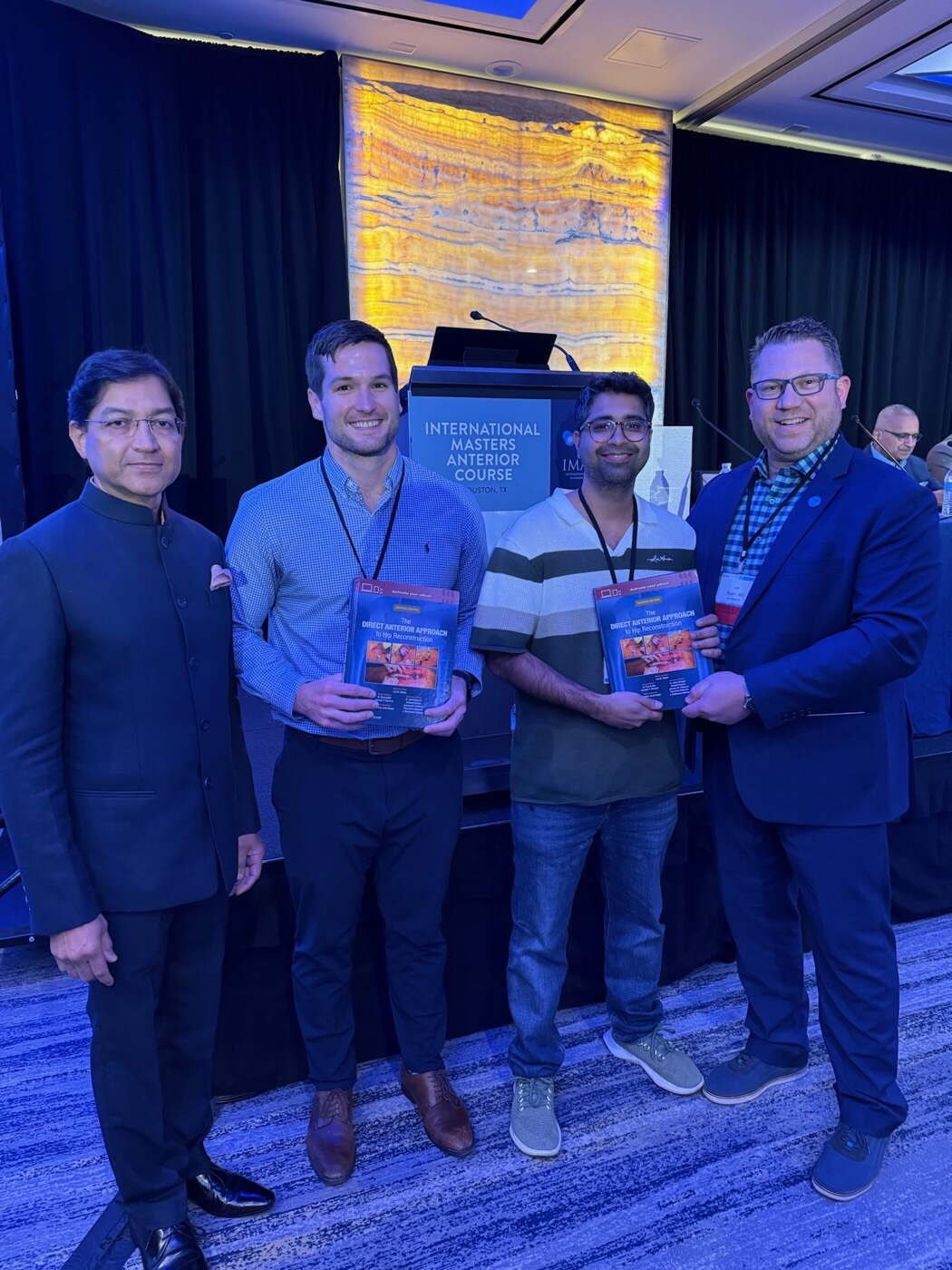 Dr Aditya Malik receiving the direct anterior approach textbook from its author, Dr Lee Rubin, in Houston